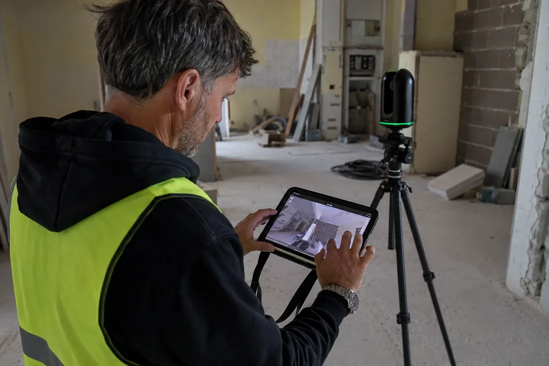 Operatore con tablet durante scansione laser 3D in cantiere